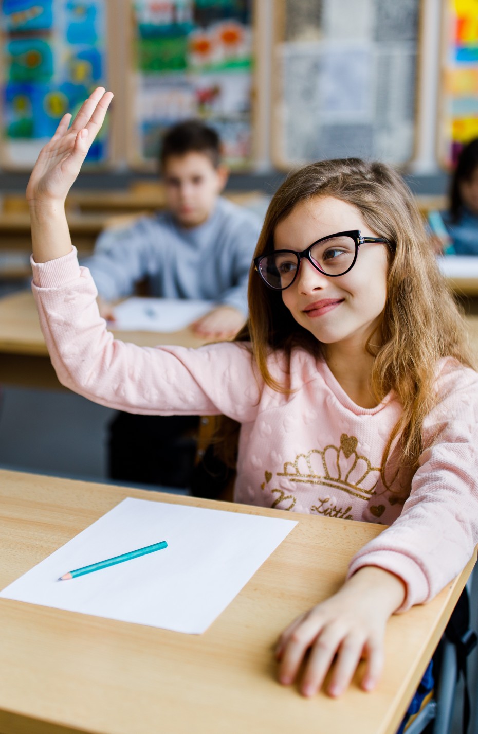 Myopie: Schülerin mit Brille meldet sich im Unterricht